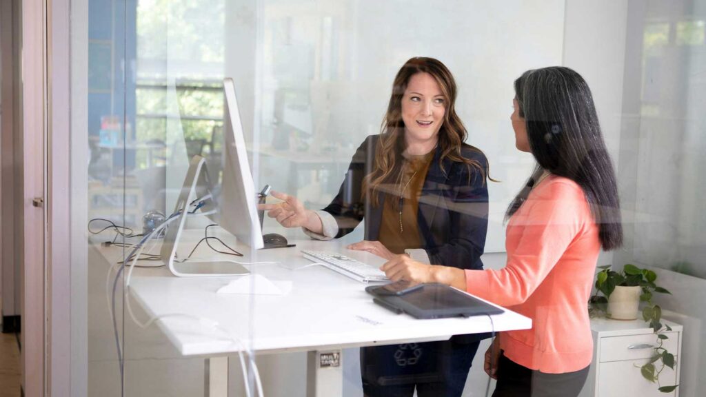 a group of women looking at a computer screen and discussing Abstractor title