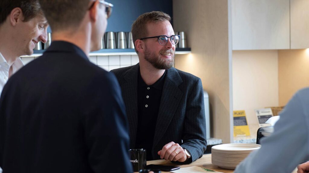 a man in a suit sitting at a table with other men discussing Easement Appurtenant