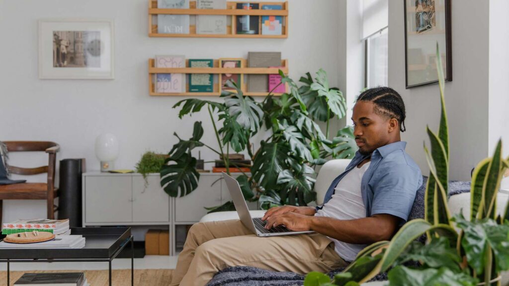 a man sitting on a couch using a laptop Same-Day Title Updates