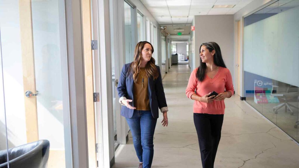 a group of women walking in a hallway webhook