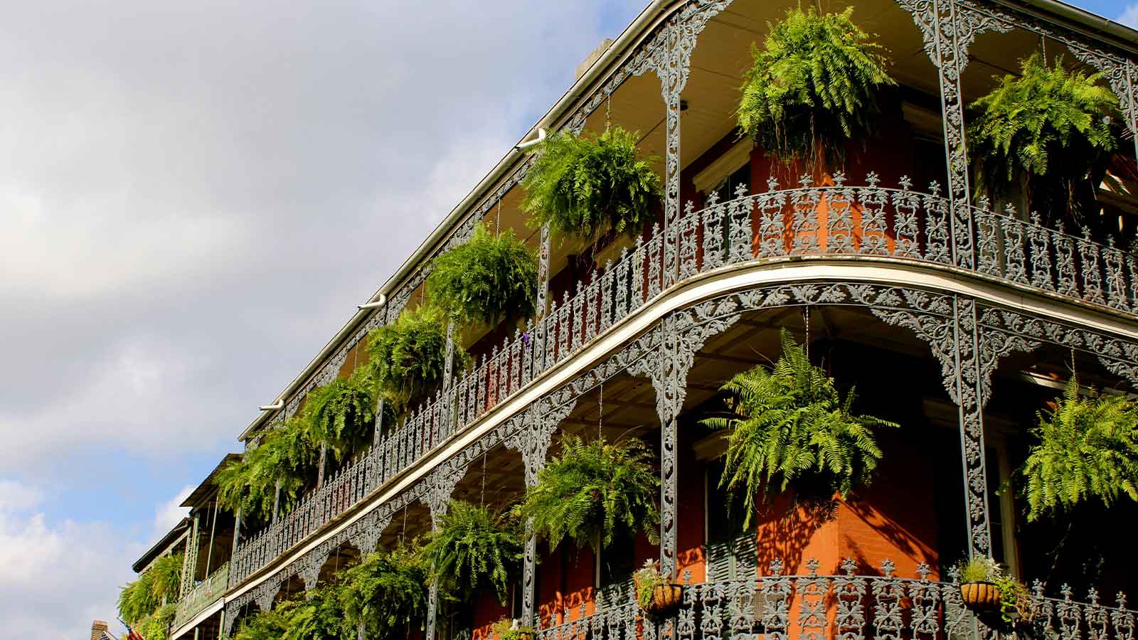 Wrought iron balconies above a narrow street in warm late afternoon light